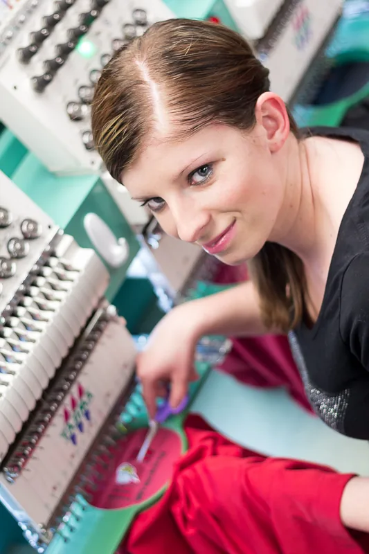 Technician running an embroidery machine