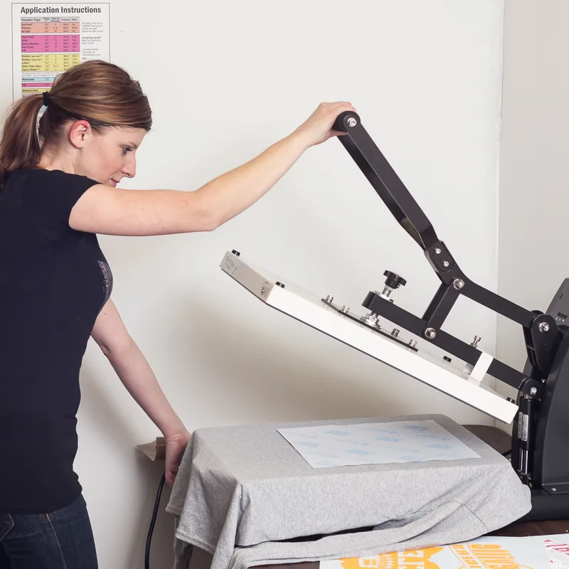 Heat press operator applying a transfer to a garment