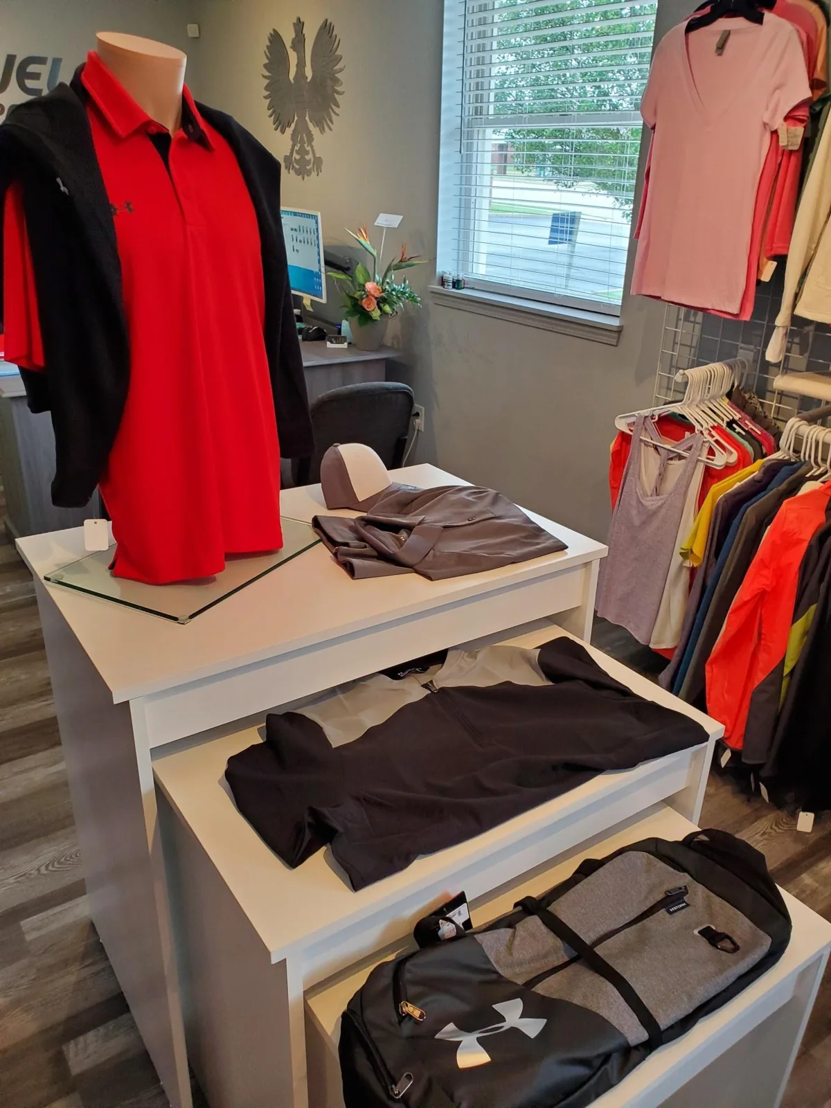 Mannequin displaying a red polo with embroidered logo
